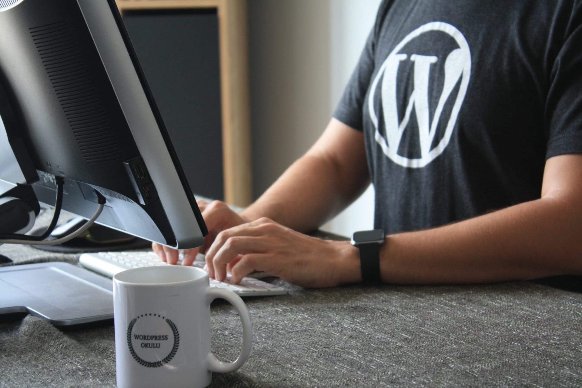 Man on computer typing with a wordpress t shirt